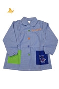 Babi azul personalizado con botones de colores, cuello, goma en las mangas y dos bolsillos.