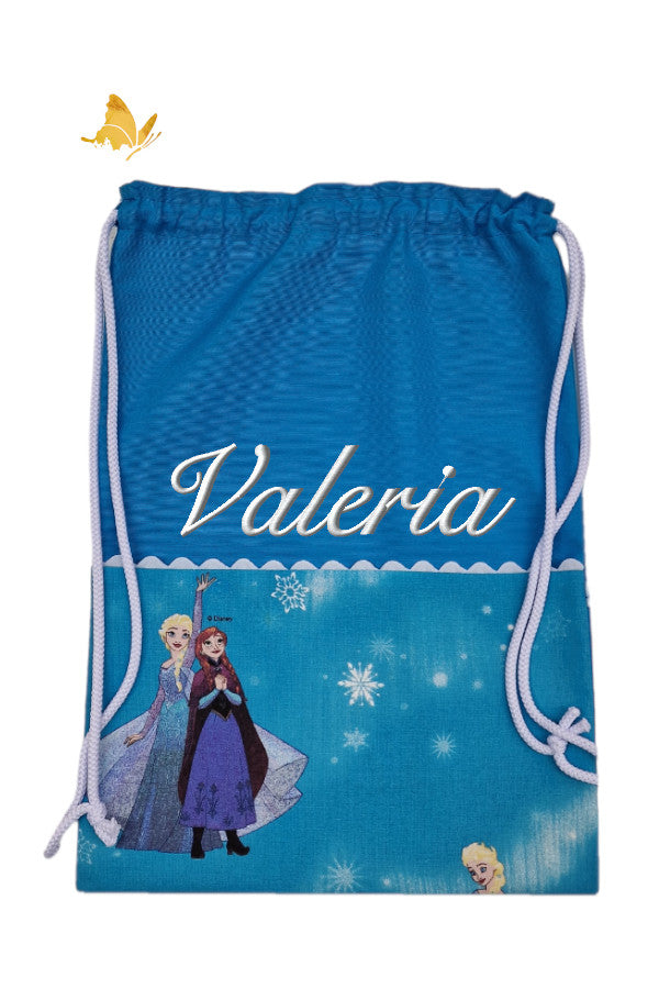 Mochila infantil Frozen azul bordada con nombre, bolsillo turquesa y asas blancas, hecha a mano por Bordados de Tania