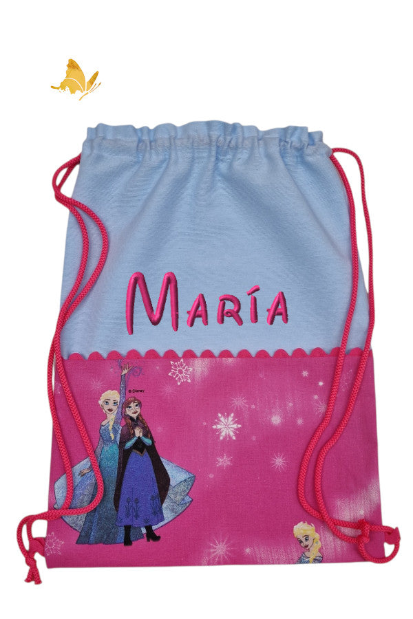 Mochila infantil Frozen azul claro bordada con nombre, de loneta, bolsillo y asas fucsia, hecha a mano por Bordados de Tania 